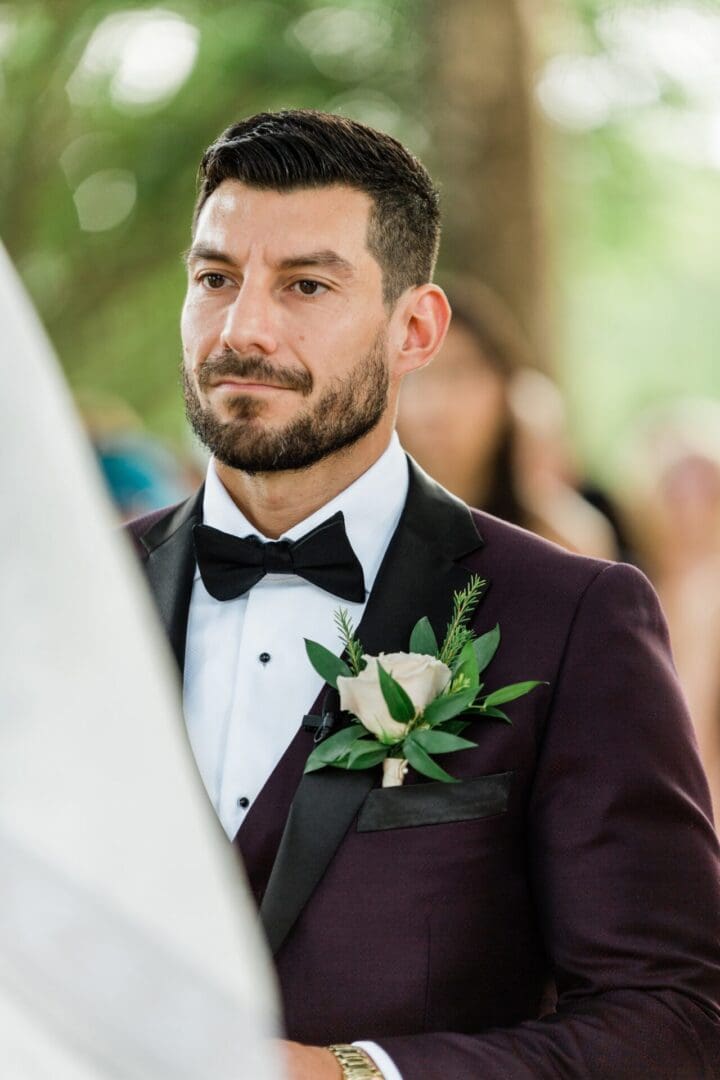 A man in a tuxedo with a flower on his lapel.