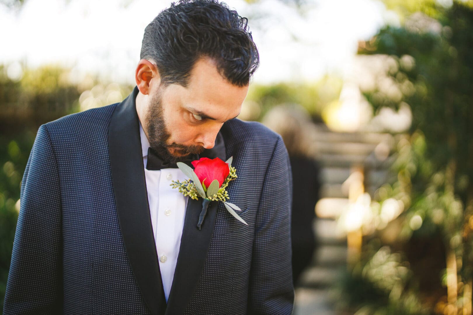A man in a tuxedo with a rose in his lapel.