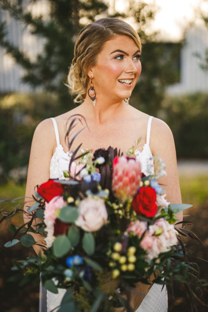 A woman holding a bouquet of flowers in her hand.