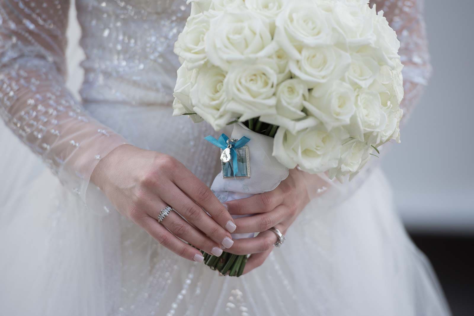 A bride holding her bouquet of white roses.