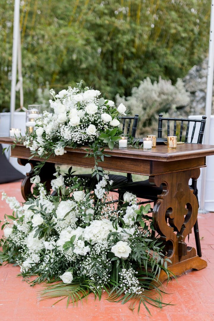 A wooden table with flowers on top of it.