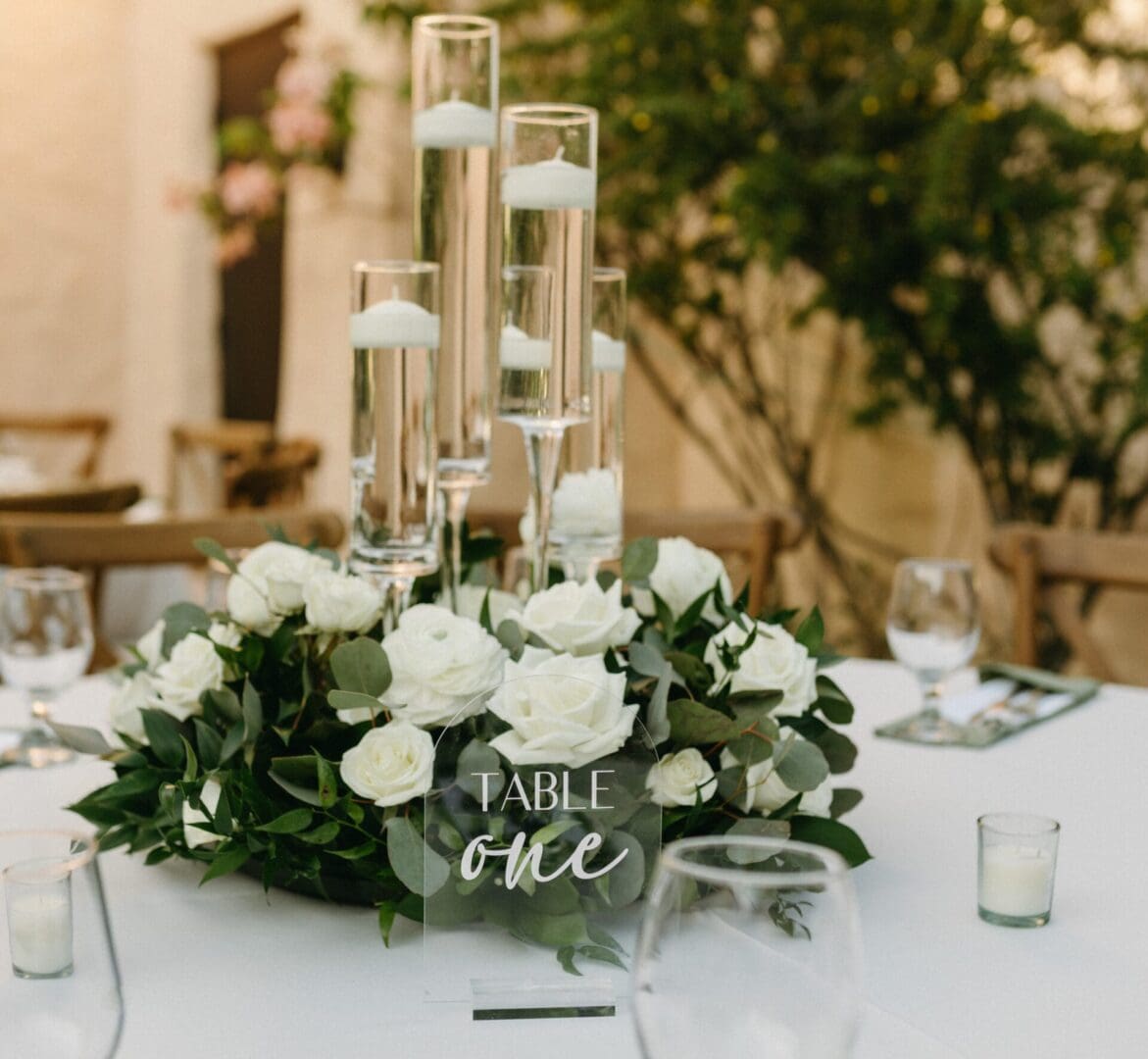 A table with white flowers and candles on it