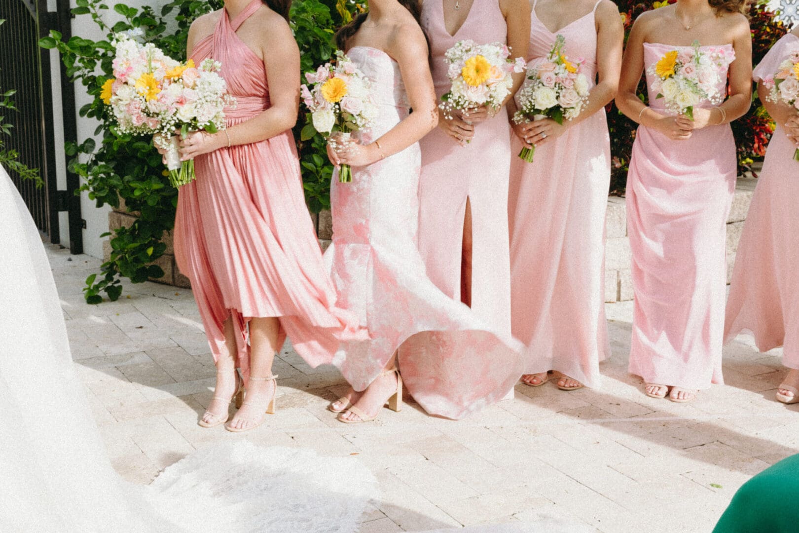 A group of women in pink dresses holding flowers.