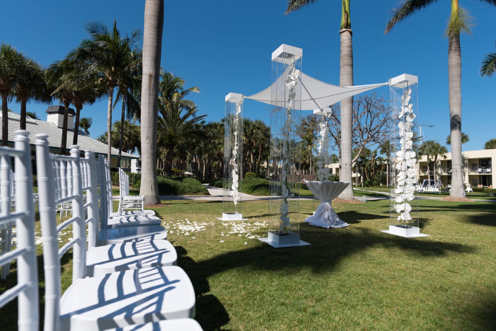 A white gazebo with palm trees in the background.
