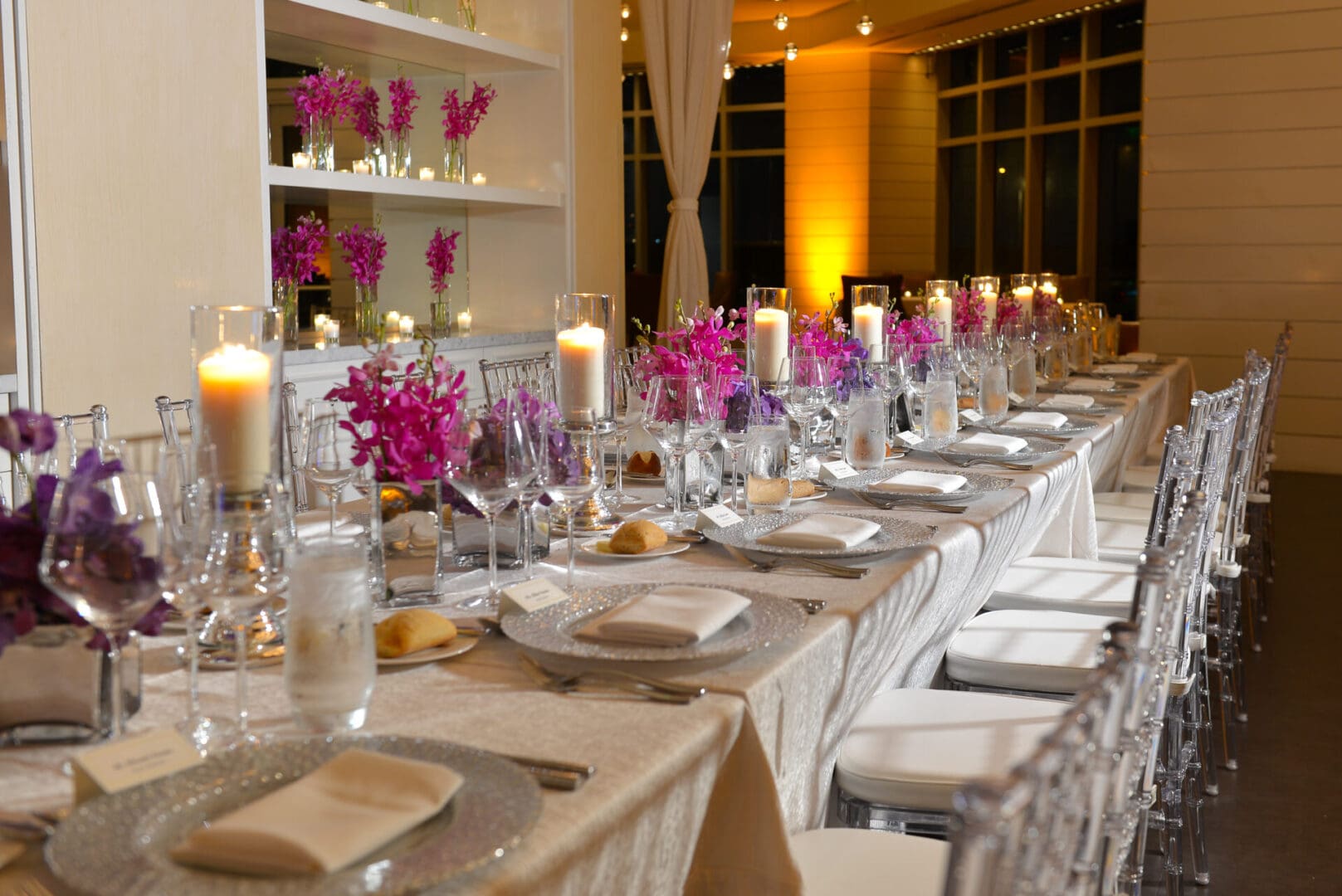 A long table with many plates and candles on it